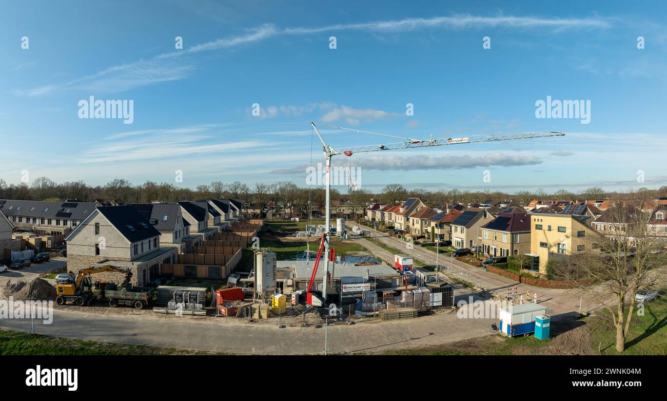 OLDENZAAL, NIEDERLANDE - 2. MÄRZ 2024: Luftaufnahme einer Baustelle mit großem Kran in einem Wohngebiet Stockfoto