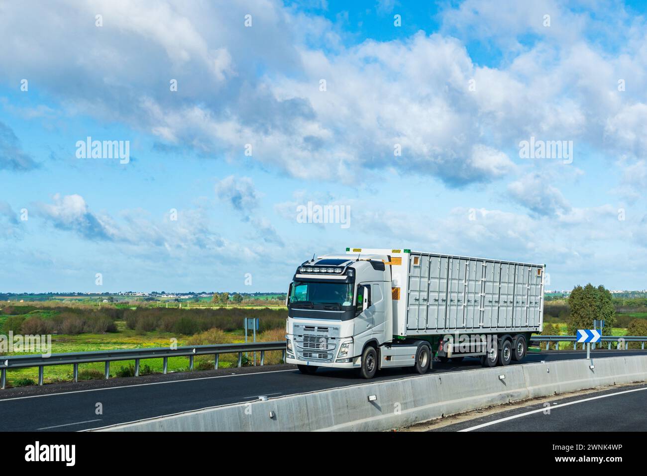 Lkw mit offenem Container, der auf der Straße fährt, Container für den Seeverkehr mit Türen an den Seiten. Stockfoto