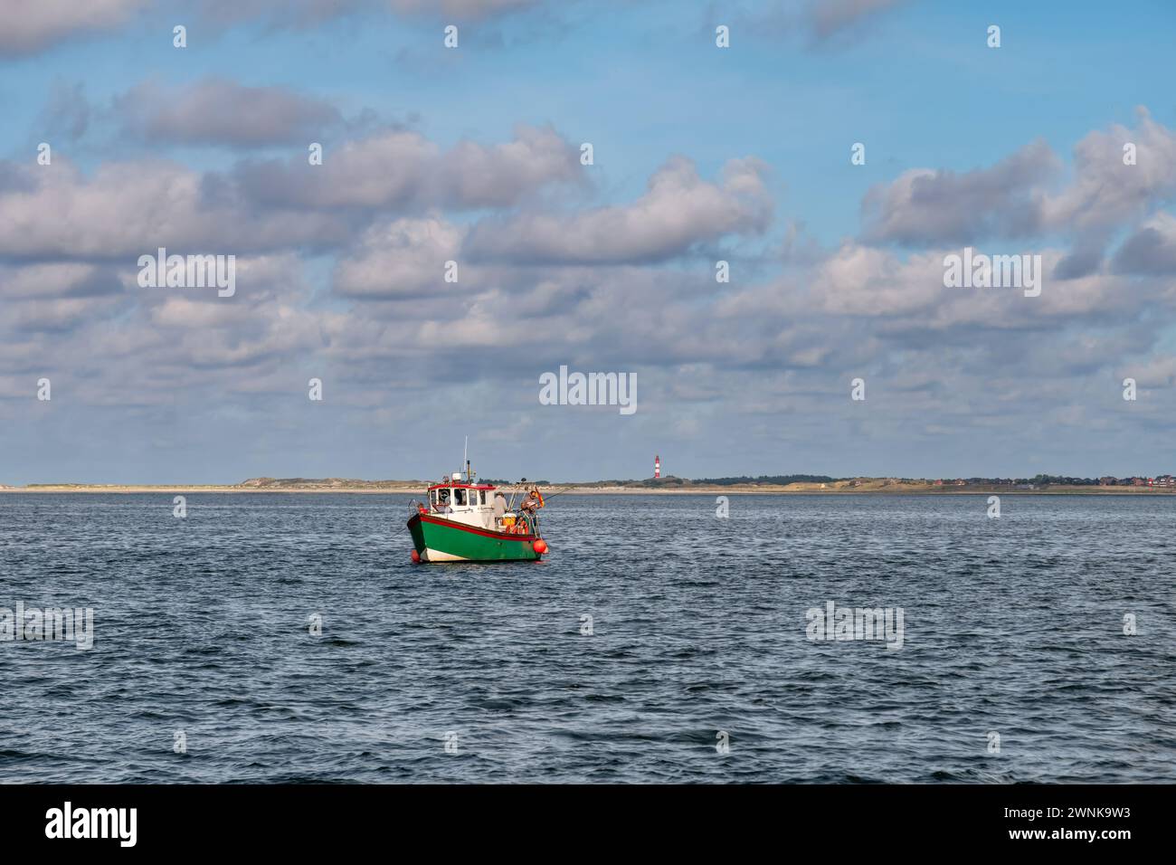 Menschen fischen auf einem kleinen Boot im Wattenmeer in der Nähe der Amrumküste und des Leuchtturms, Nordfriesland, Schleswig-Holstein, Deutschland Stockfoto