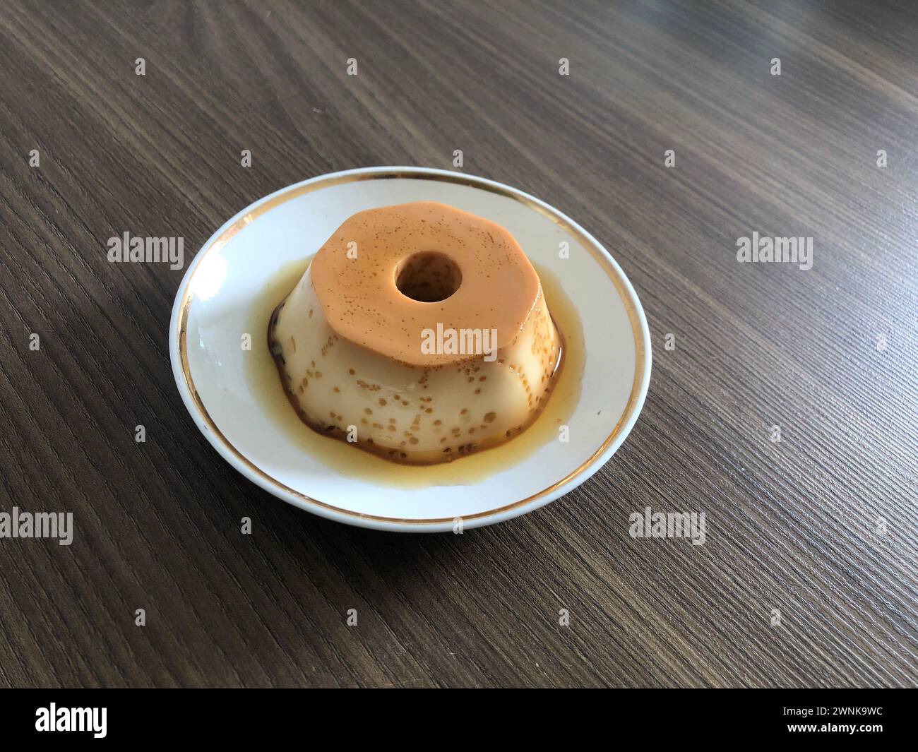 Milchpudding oder Pudim de leite. Brasilianischer Nachtisch hausgemachter Karamell-Pudding. Traditioneller brasilianischer Flan auf Holzhintergrund Stockfoto