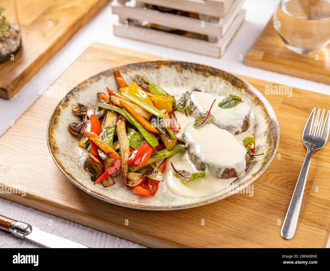 Gegrillte Schweinekoteletts mit geröstetem Gemüse, serviert mit Sauce, Restaurant-Menü Stockfoto