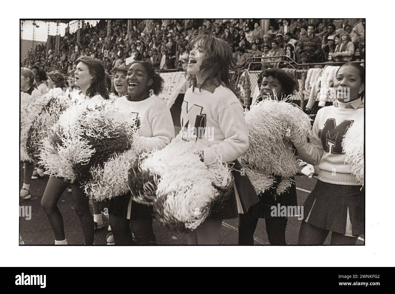 High-School-Cheerleader schütteln ihre Pompons bei einem Spiel im Midwood Field in Brooklyn, New York. Nicht sicher, aber ich glaube, diese Mädchen sind von der Midwood High. Stockfoto