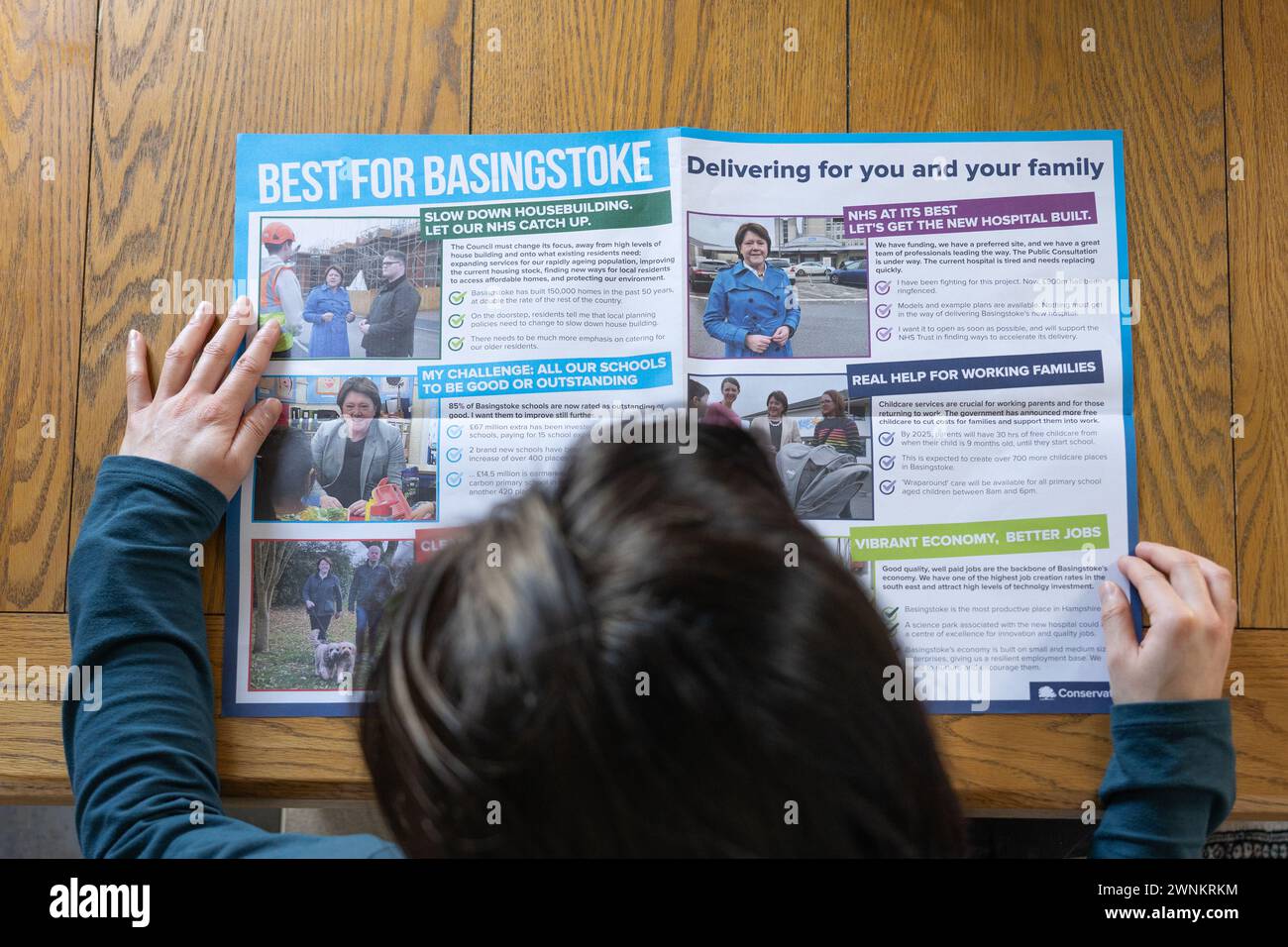 Eine britische Frau / Wählerin hält und liest einen Wahlblatt der Konservativen im Mai 2024 für einen Parlamentsabgeordneten in Basingstoke. Thema: Kommunalwahlen, Sitze im rat Stockfoto