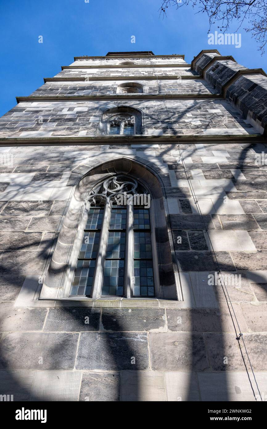 Coburg, Deutschland. März 2024. Ein blühender Baum wirft seinen Schatten über die evangelisch-lutherische Stadtkirche St. Moriz in Coburg. Bei frühlingshaften Temperaturen wird in Coburgs ältester Kirche die Hälfte der zweiten Vesperkiche in Coburg gefeiert. Quelle: Pia Bayer/dpa/Alamy Live News Stockfoto