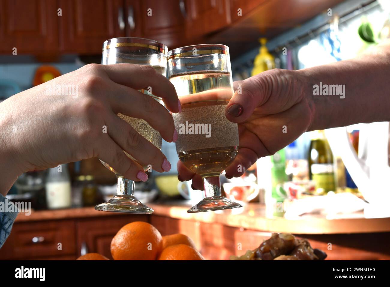 Weingläser in den Händen der feiernden Leute trafen auf klirrende Gläser über dem Tisch. Stockfoto