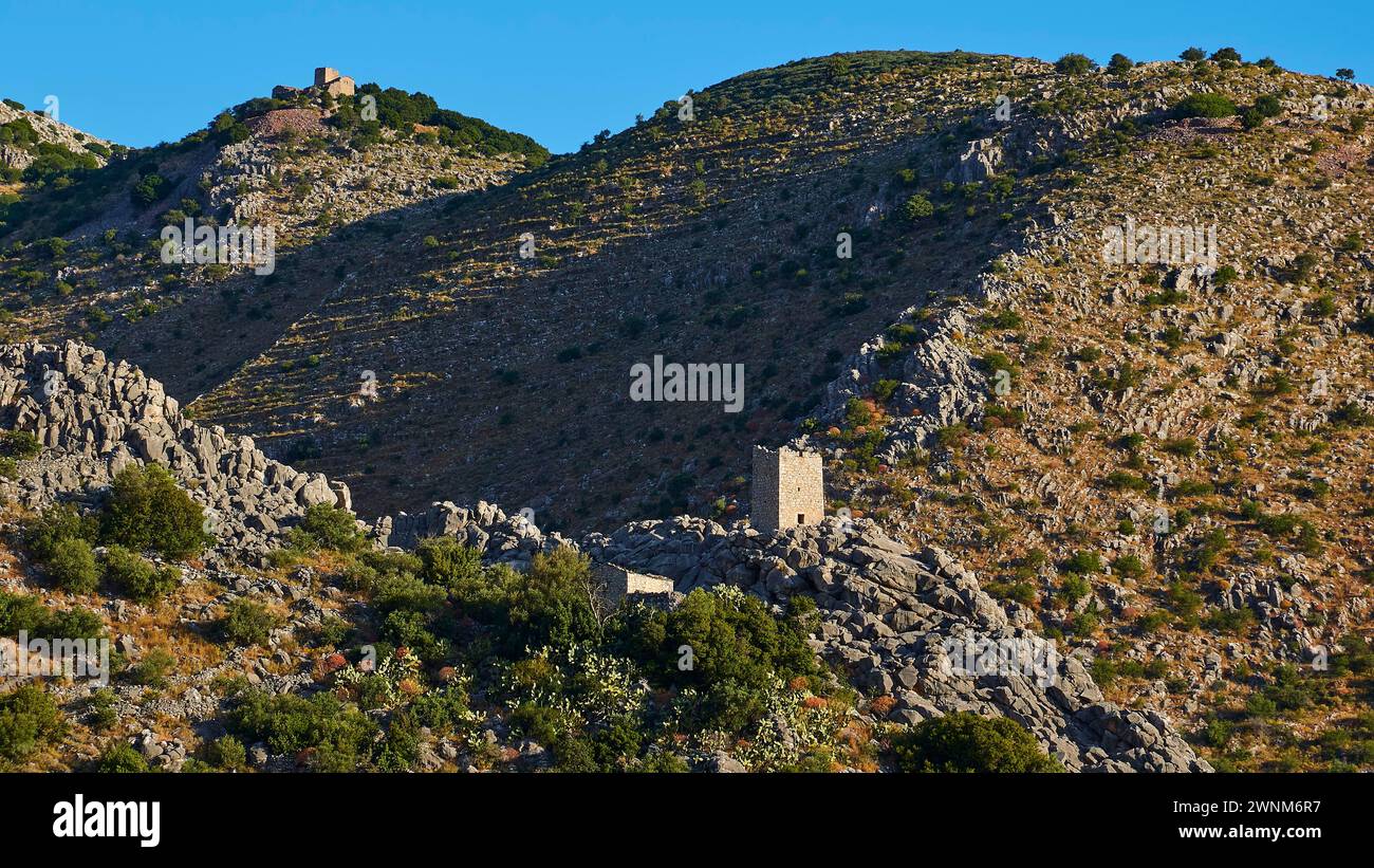 Sonnendurchflutete Burgruinen auf einem Berg mit felsiger Umgebung und grüner Vegetation, Mani Halbinsel, Peloponnes, Griechenland Stockfoto