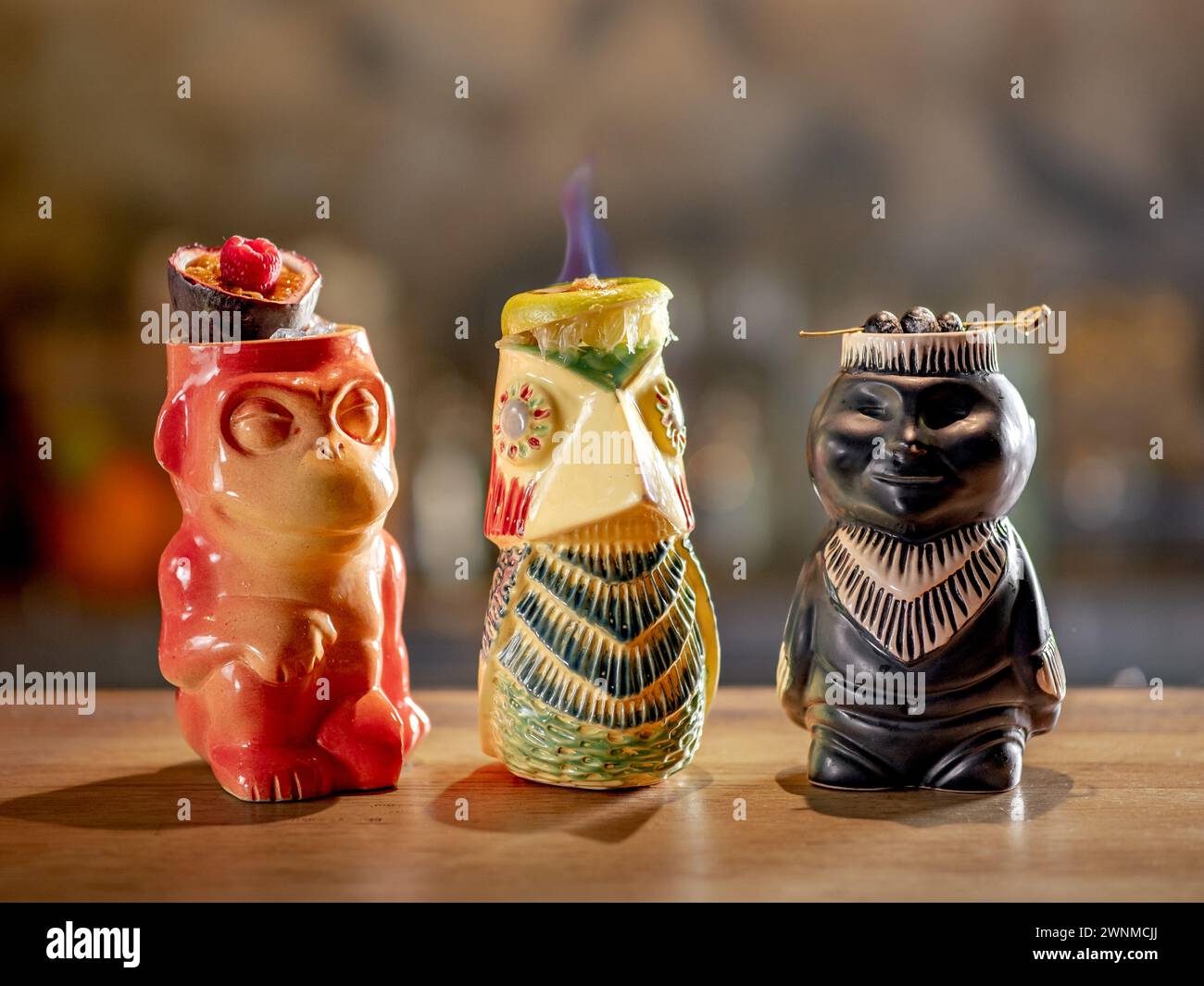 Tiki Drink Cocktails Kollektion. Set mit drei tropischen Tiki-Cocktails an der Bar. Wunderschöne Tiki-Cocktails, unterschiedlich dekoriert mit Feuerflamme an der Bar im Nachtclub Stockfoto