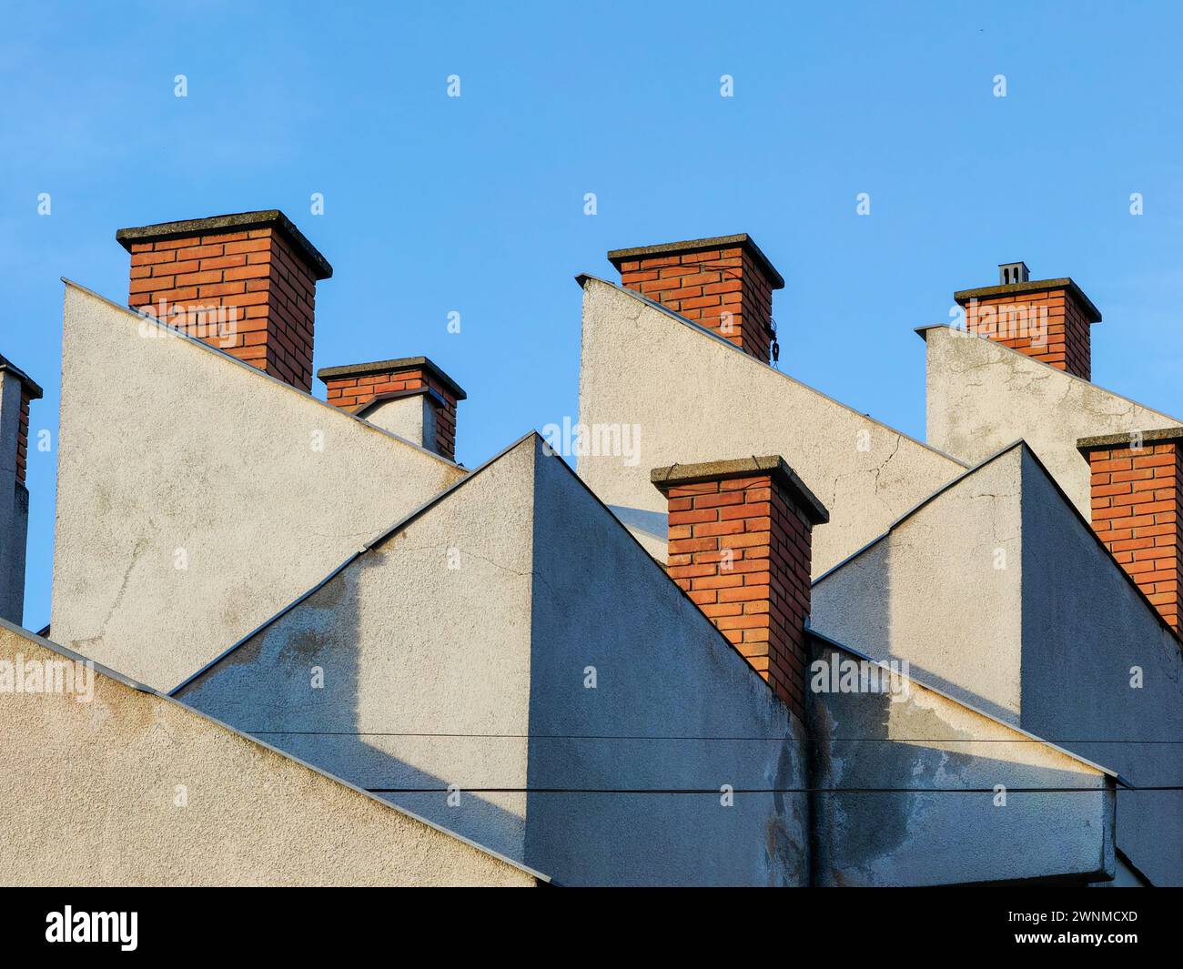 Oben aufsteigen. Bauen Sie Ziegelsteine auf dem Dach vor der riesigen blauen Skyline. Stockfoto