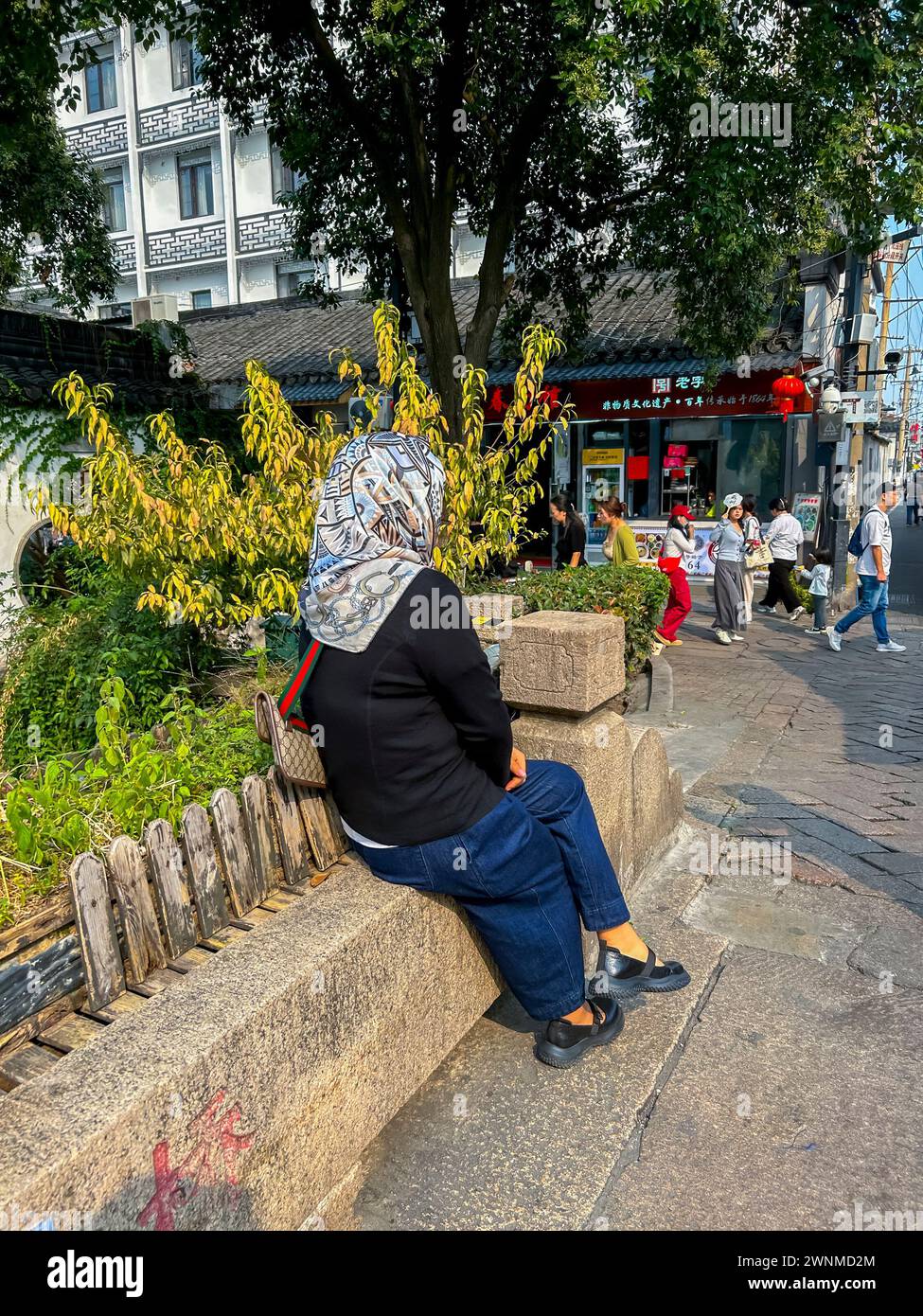 Suzhou, China, chinesische Touristen, Frau im Kopftuch, sitzend auf Straßenszenen, Altstadt historisches Zentrum Stockfoto