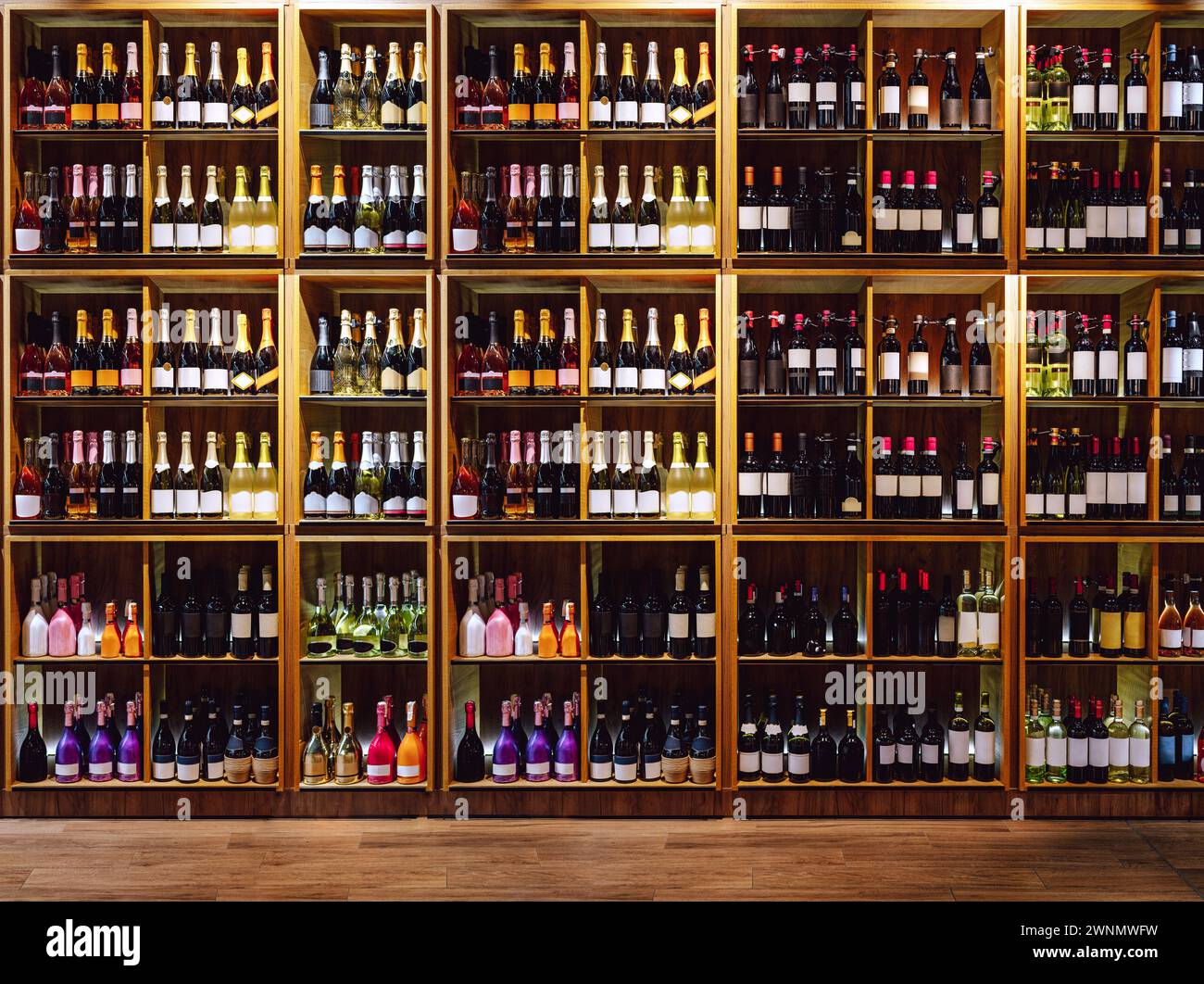 Blick von vorne auf die Regale mit großer Weinauswahl. Wein- und Sektflaschen auf den Regalen. Stockfoto