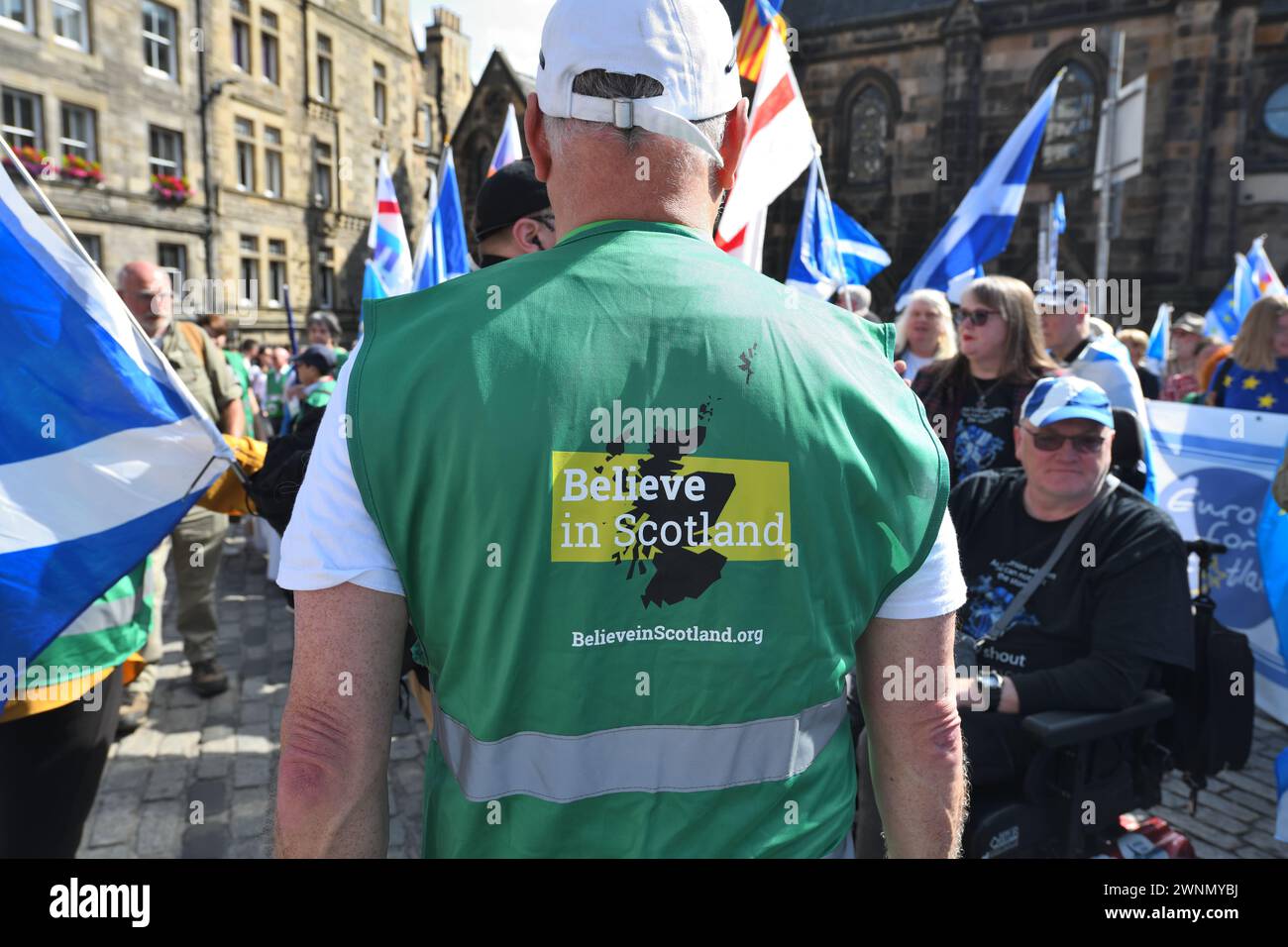 Ein Steward, der auf einem marsch zur Unterstützung der schottischen Unabhängigkeit eine Believe in Scotland-Weste trägt. Stockfoto