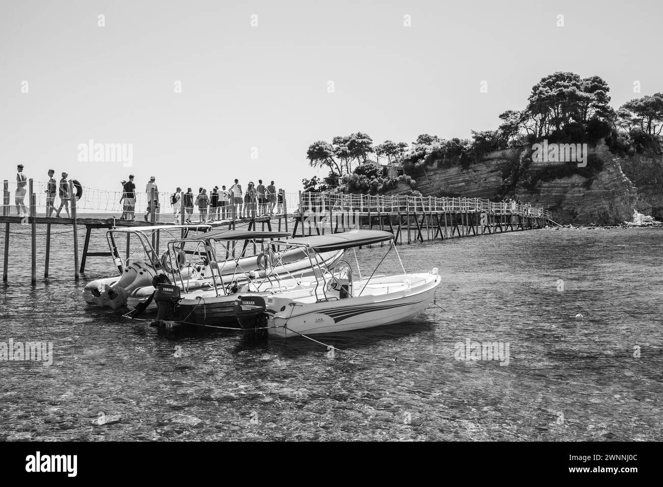 Zakynthos, Griechenland - 17. August 2016: Touristen auf der Brücke zu Fuß von Agios Sostis. Freude Motorboote sind in der Nähe von Cameo Insel an der sonnigen Sommer günstig da Stockfoto