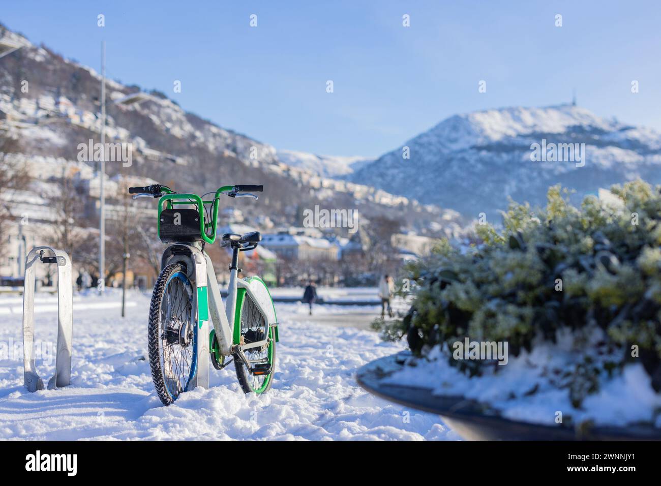 Leihfahrräder in Bergen, Norwegen an einem sonnigen Wintertag. Fahrradständer mit Leihfahrrad bedeckt und von Schnee umgeben. In der Nähe des Sees im Zentrum von Bergen, Single BI Stockfoto