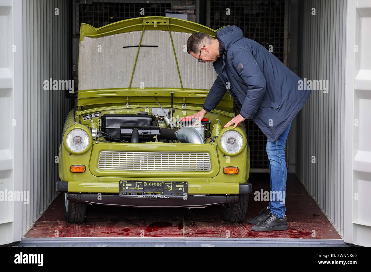 09. Februar 2024, Sachsen, Zwickau: Frank Hofmann steht auf dem Gelände seiner Firma Trabantwelt neben einem originalgetreu wiederaufgebauten Trabant P 601. Der Online-Händler bietet alle Teile des Trabant als Ersatzteile an. Der Trabant 601 wurde vor 60 Jahren auf der Leipziger Frühjahrsmesse dem internationalen Publikum vorgestellt. Er ersetzte die Vorgängermodelle Trabant 500 (P 50) und 600 (P 60). Bis zur Wiedervereinigung wurden mehr als 2,8 Millionen der 601er in Zwickau gebaut und damit das meistverkaufte Trabant-Modell. Seit einigen Jahren steigen die Zulassungszahlen in Deutschland wieder an, so die deutsche Fed Stockfoto