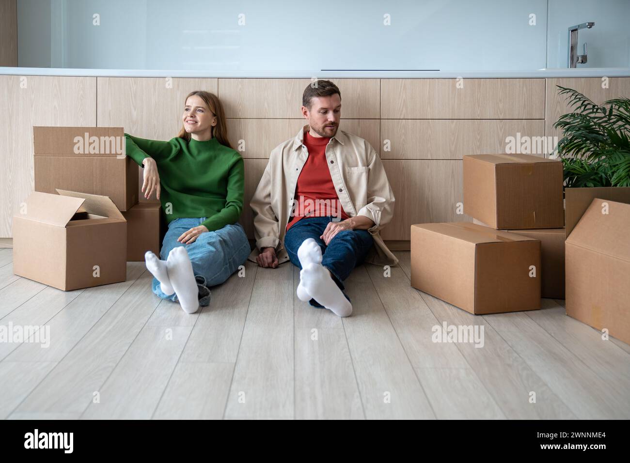 Glückliches Paar frisch vermählte im Stockwerk, neue Wohnung zwischen Umzugskartons. Beginn des Arrangements Sweet Home Stockfoto