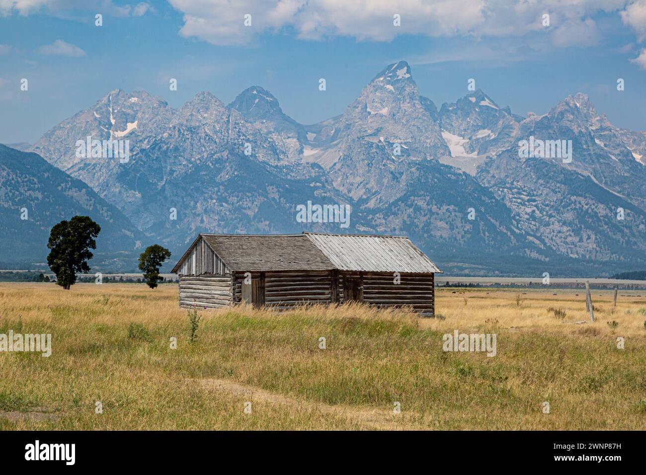 Gipfel der Grand Tetons hinter einem Außengebäude hinter der John Moulton Barn in der Mormon Row im Grand Teton National Park in Wyoming Stockfoto