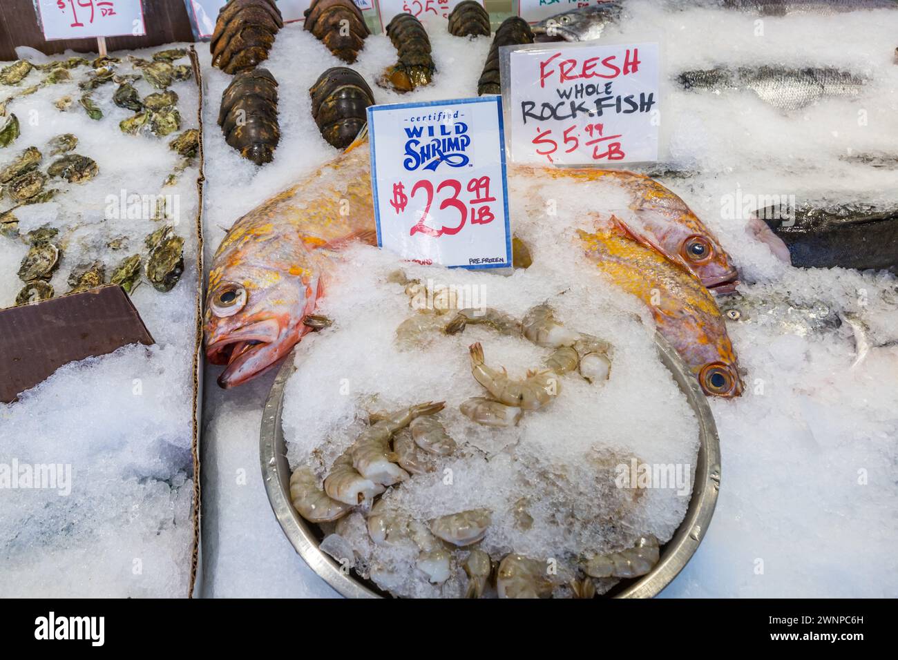Frischer Fisch und Meeresfrüchte auf Eis zum Verkauf auf dem berühmten Pike Place Fish Market in der Innenstadt von Seattle, Washington Stockfoto