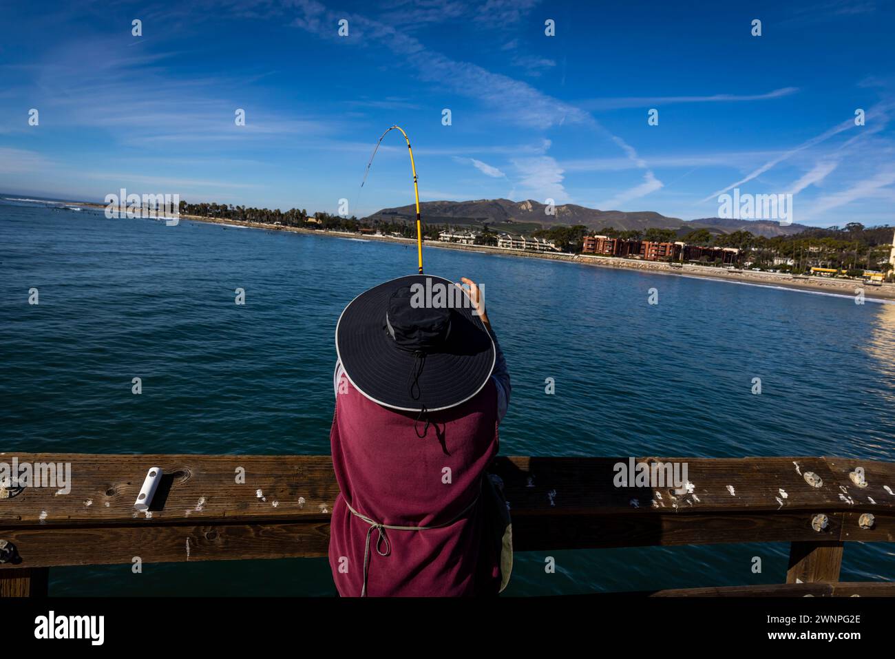 Ein Fischer fischt vom Pier aus an einem schönen, warmen Wintertag in Ventura, Kalifornien. Stockfoto