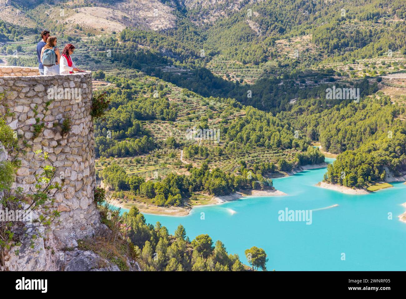 Menschen genießen den Blick über den türkisfarbenen See von Guadalest, Spanien Stockfoto