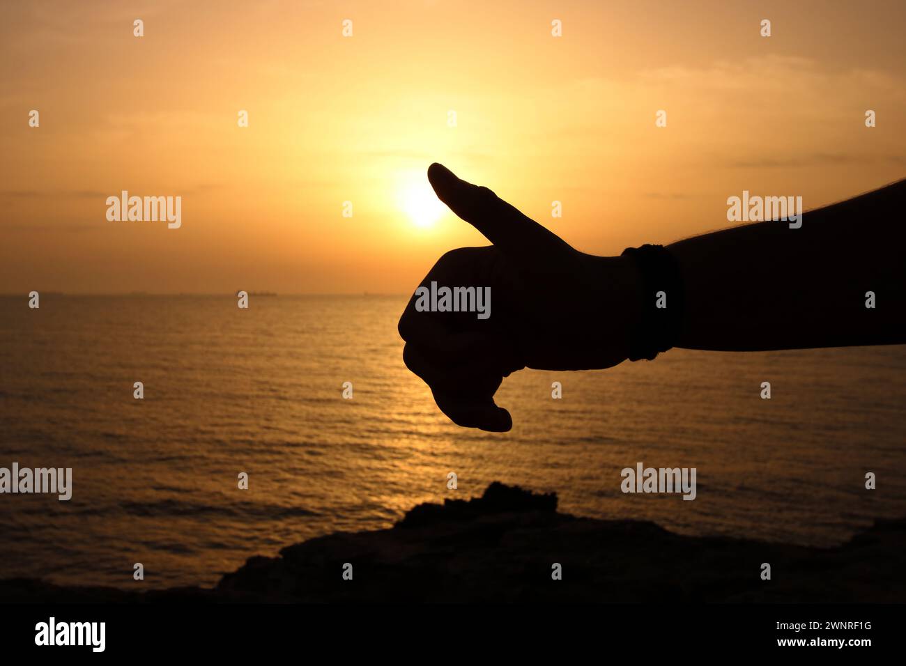 Silhouette der Daumen hoch am Meer bei Sonnenuntergang Stockfoto