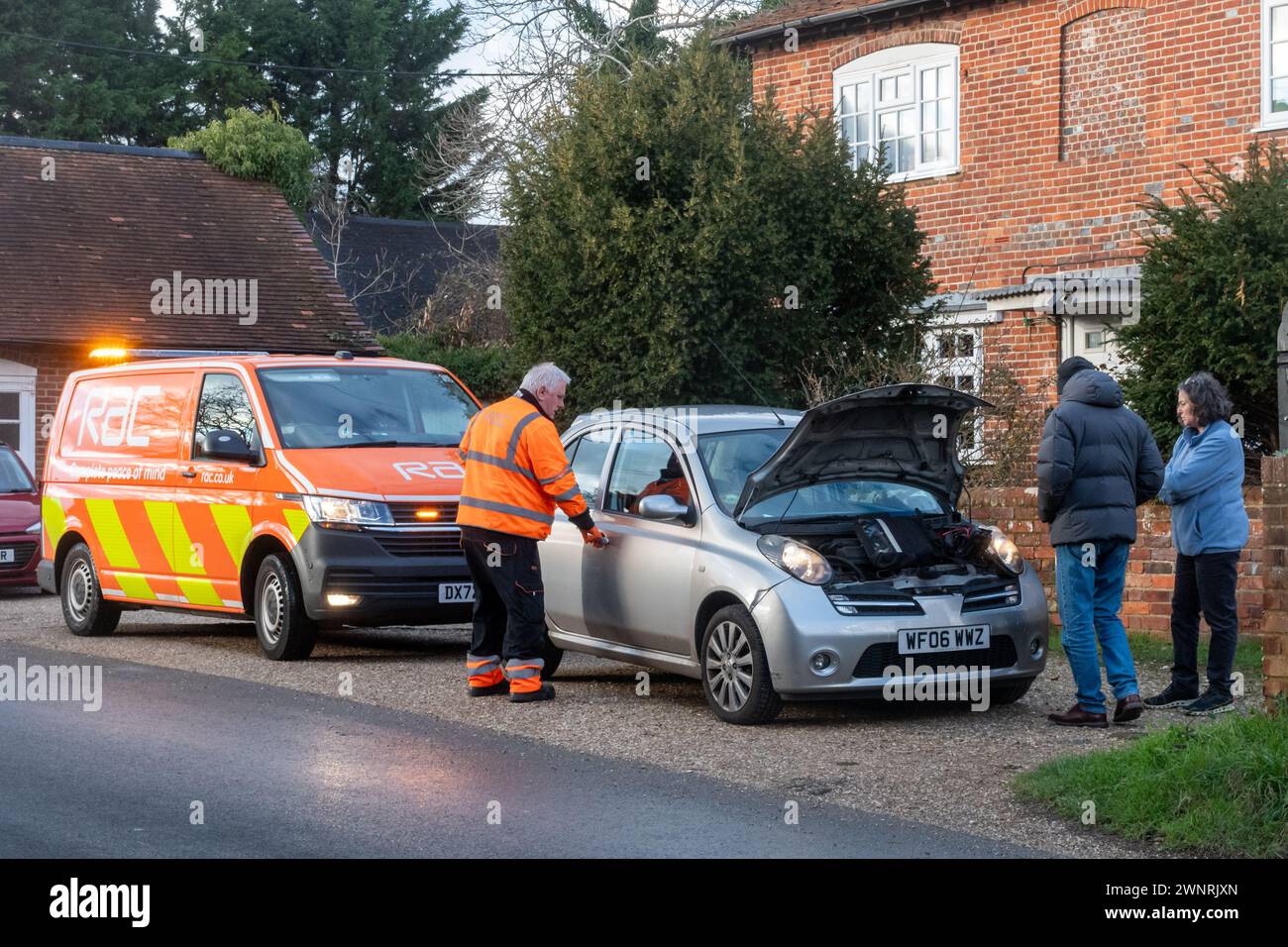 RAC-Pannendienstmitarbeiter, der einen Pannenwagen repariert, während das Paar oder die Besitzer zuschauen, England, Großbritannien Stockfoto