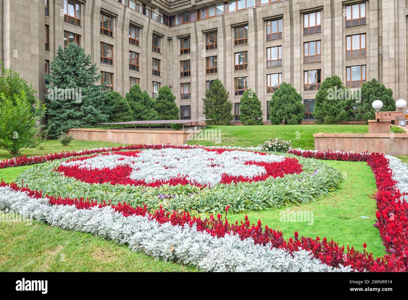 Ein farbenfrohes Blumenbeet im vorderen Innenhof der Nationalbank der Republik Kasachstan, formell das parlamentsgebäude. In Almaty, Kasachst Stockfoto