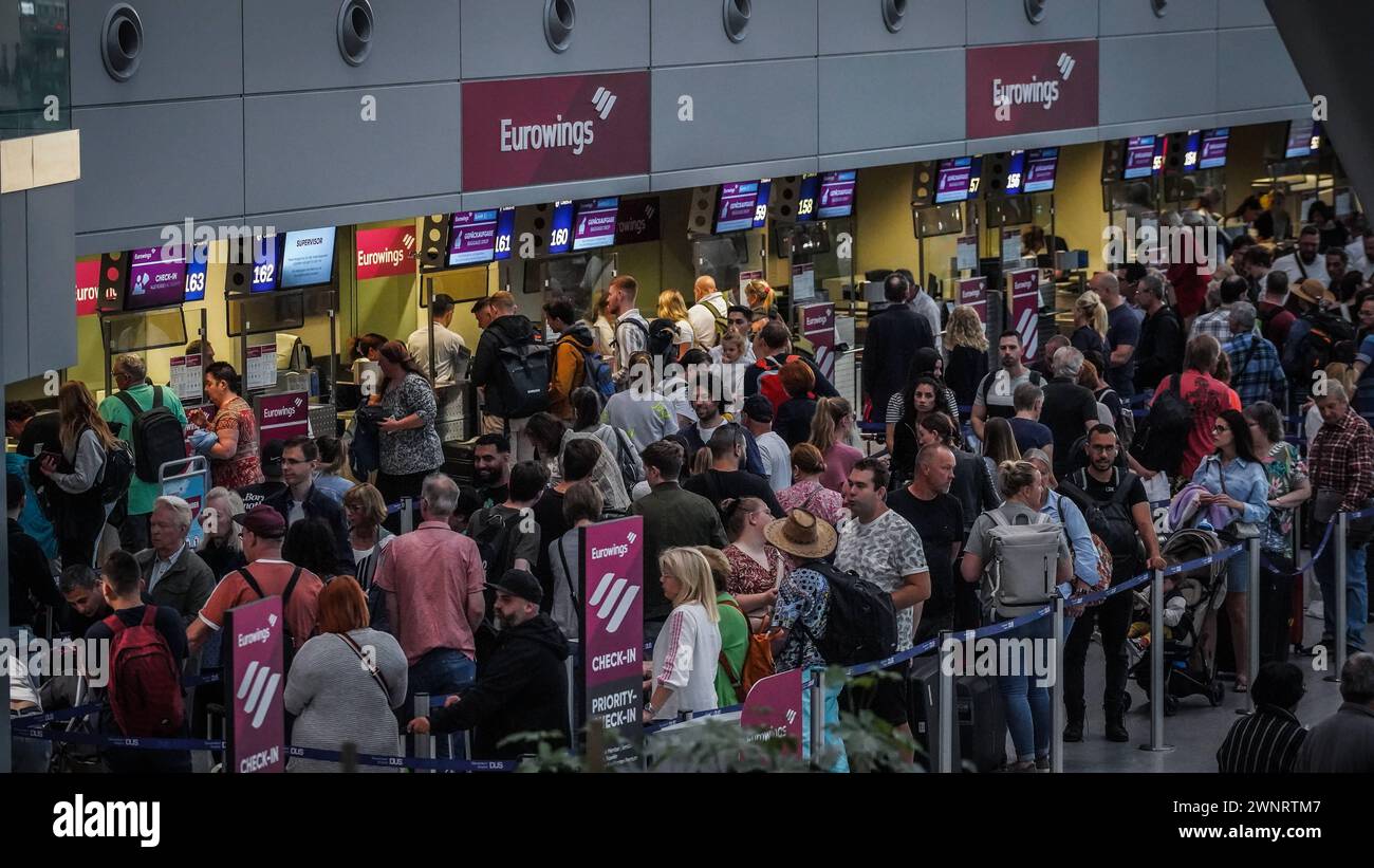 Flughafen Düsseldorf, Nordrhein Westfalen, Deutschland Europa - Impressionen am Flughafen - Warteschlangen am Check-in im Terminal und genervte Urlauber Symbolbild: Gepäckabgabe, Flugsteig, Flugzeug, Abflug, Ankunft, Flugplan, Reisevorbereitung, Flughafenpersonal, Gate, Verspätung, Reisegruppe, Passkontrolle, Zollkontrolle, Gepäckband, Flughafenlounge, Duty-Free-Shop, Sicherheitspersonal, Boarding-Prozess, Flughafenbus, Rolltreppe, Gepäckwagen, Flugreisender, Reisegepäck, Reisepasskontrolle, Flugverspätung, Terminalgebäude, Passagierabfertigung, Flugziel, Flughafenterminal, Anzeigetafel, Reise, Stockfoto