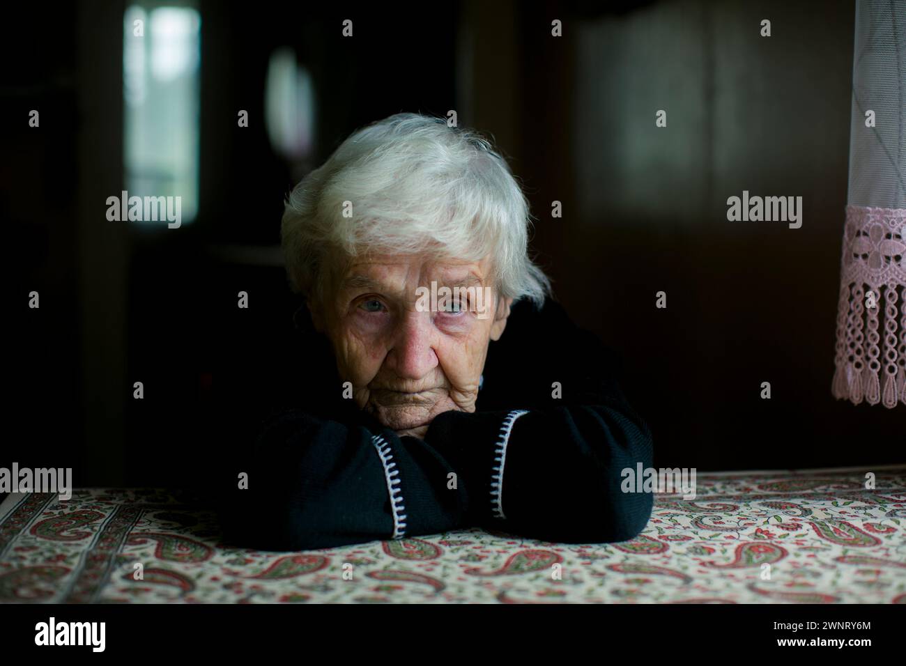 Ein dramatisches Porträt einer älteren grauhaarigen Frau. Stockfoto