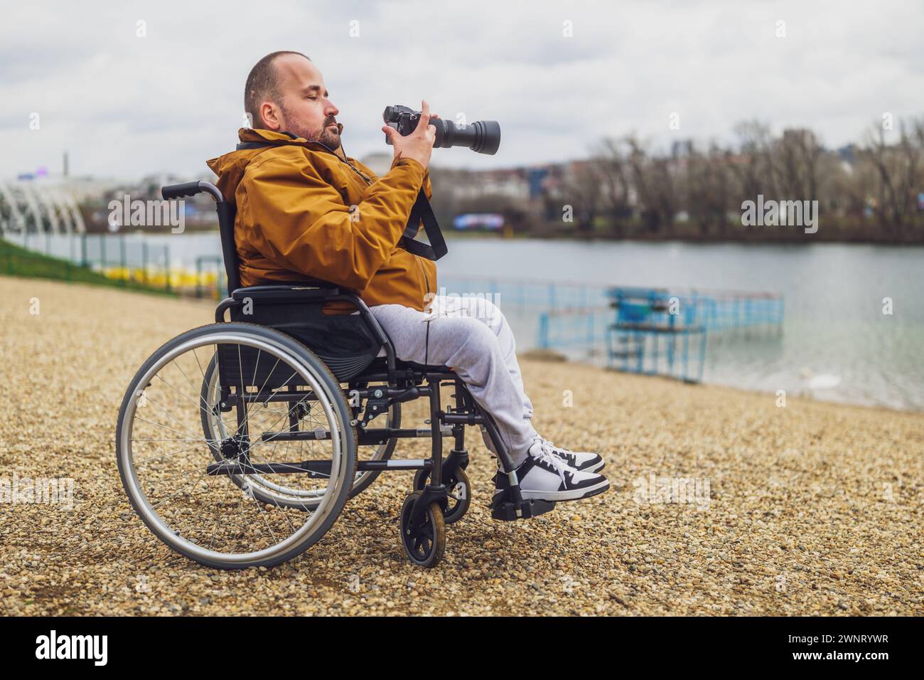 Querschnittsgelähmter behinderter Mann im Rollstuhl fotografiert draußen. Stockfoto