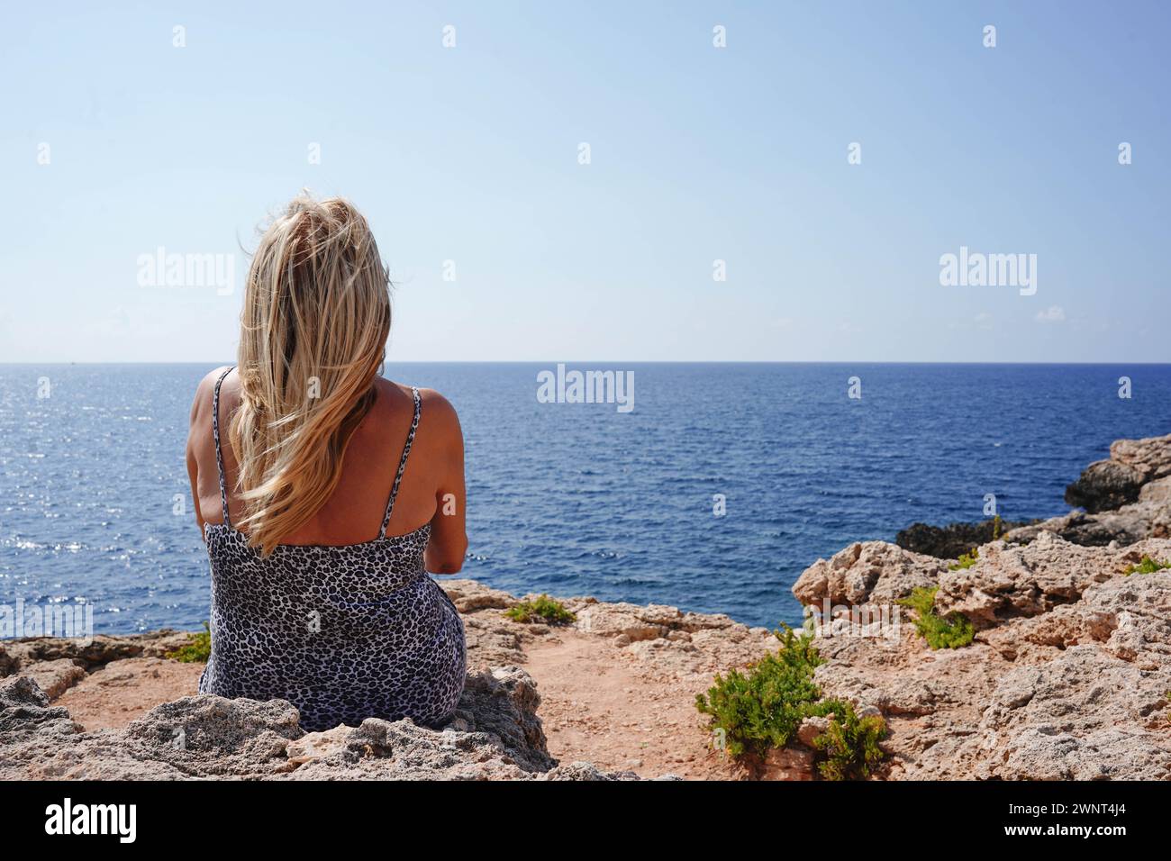 Rückansicht einer Reifen Frau, die im Sommer den Horizont im Meer sieht Stockfoto