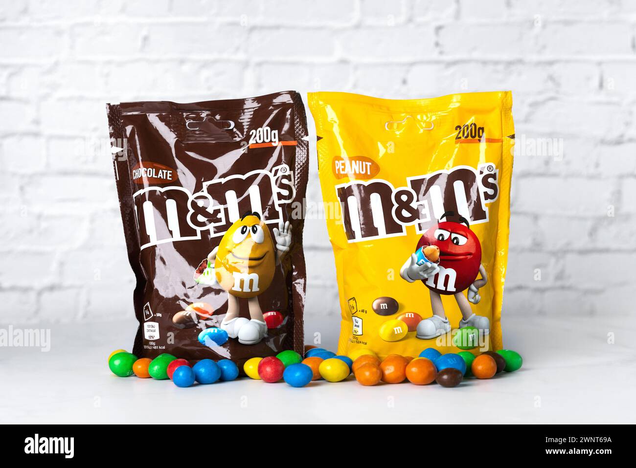 Großaufnahme von Packungen mit M&M Schokolade und Erdnuss auf einem weißen Tisch. Illustrativer Leitartikel Stockfoto