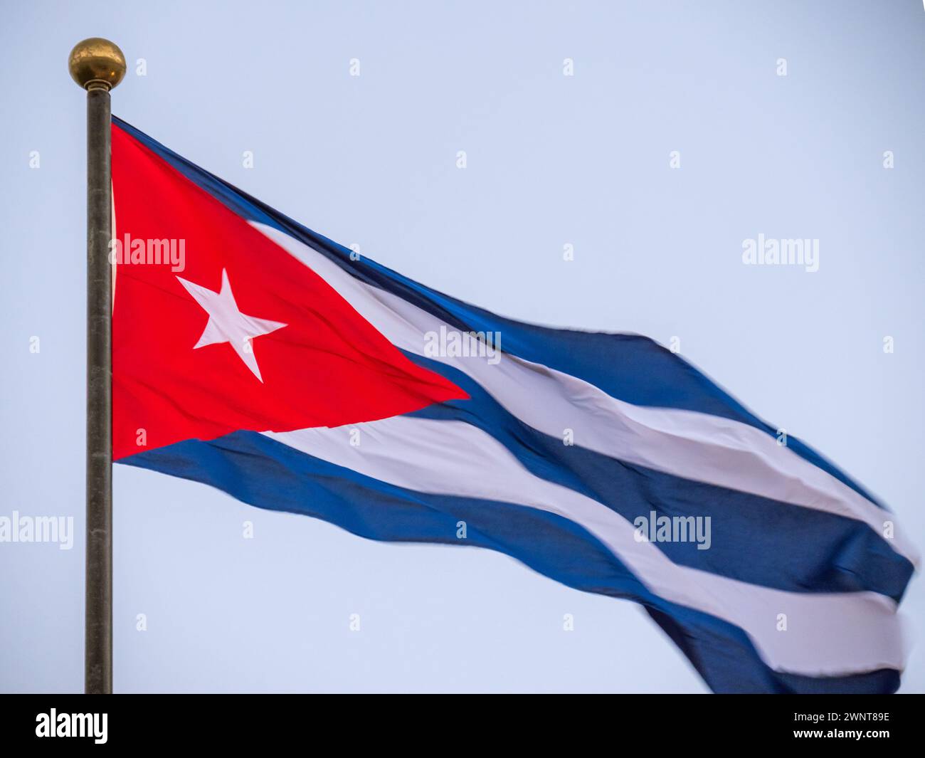 Kuba-Flagge winkt auf Fahnenmast. Kuba-Flagge, die im Wind aufschlägt. Nahaufnahme einer kubanischen Flagge, die im Wind vor klarem Himmel fliegt. Kuba-Flagge dramatischer Look, Ansicht von unten Stockfoto