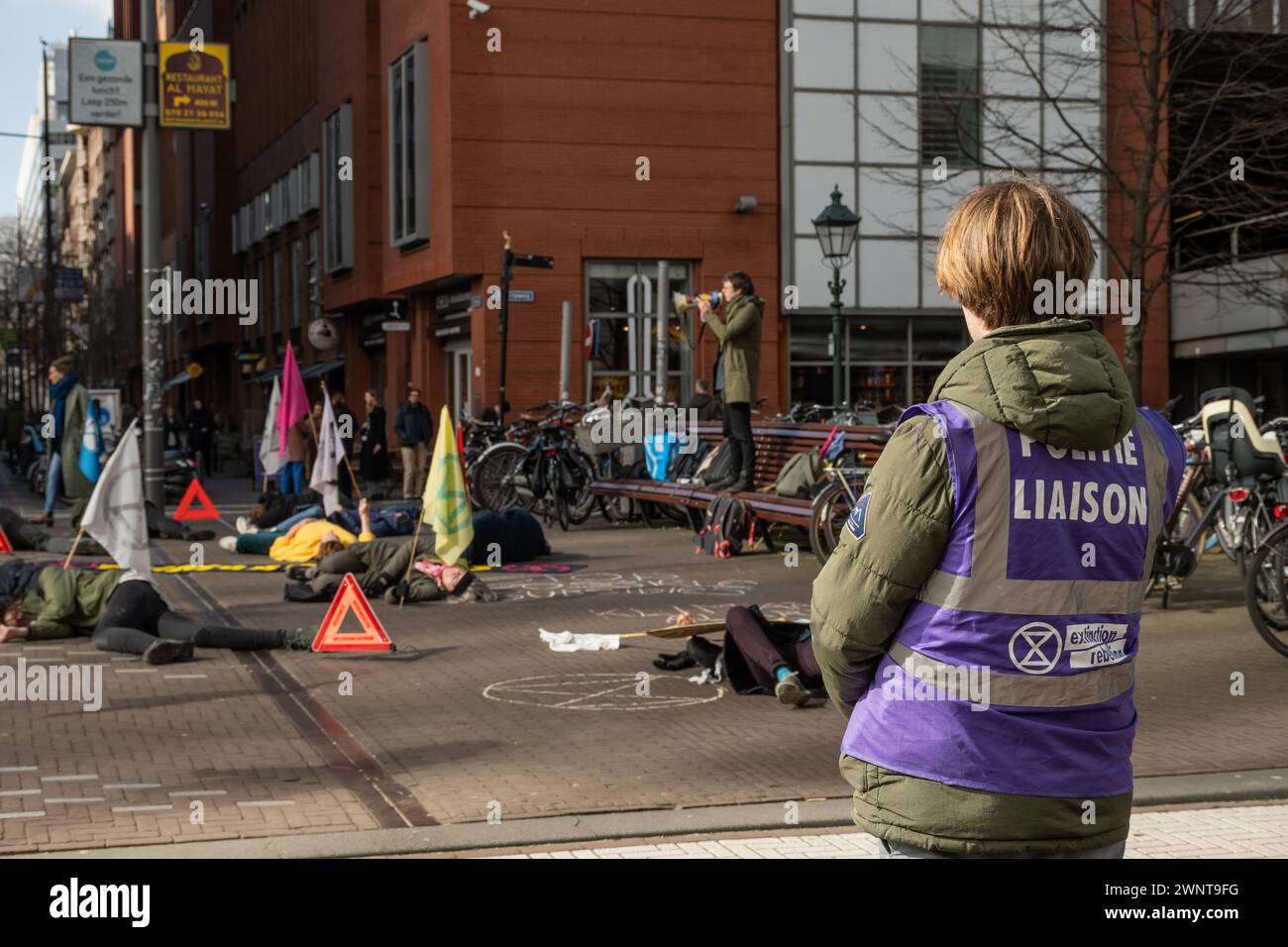 Den Haag, Niederlande. März 2024. Aktivisten der direkten Aktionsgruppe Extinction Rebellion protestieren friedlich für das Bewusstsein für den Umweltklima. Monatliche Luftangriff-Warnsirene als Alarm und Demonstranten die-in Credit: Drew McArthur/Alamy Live News Stockfoto