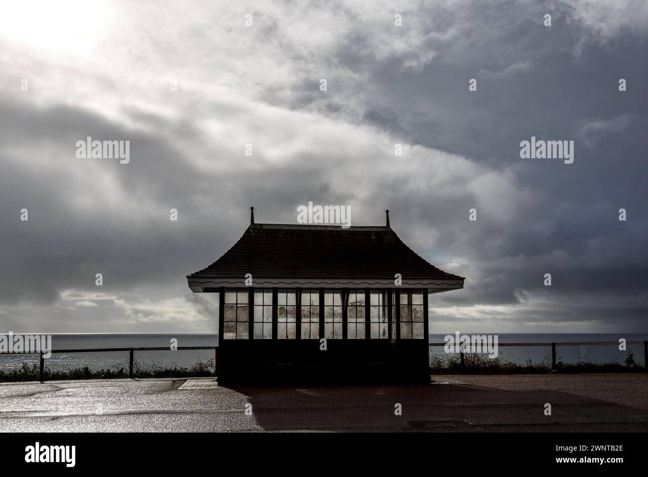 Ein einsamer Zufluchtsort an einer Promenade unter einem stürmischen Himmel, der einen klassischen englischen Urlaub am Meer andeutet! Horizontales Format mit Leerzeichen für Text. Keine Zahlen Stockfoto