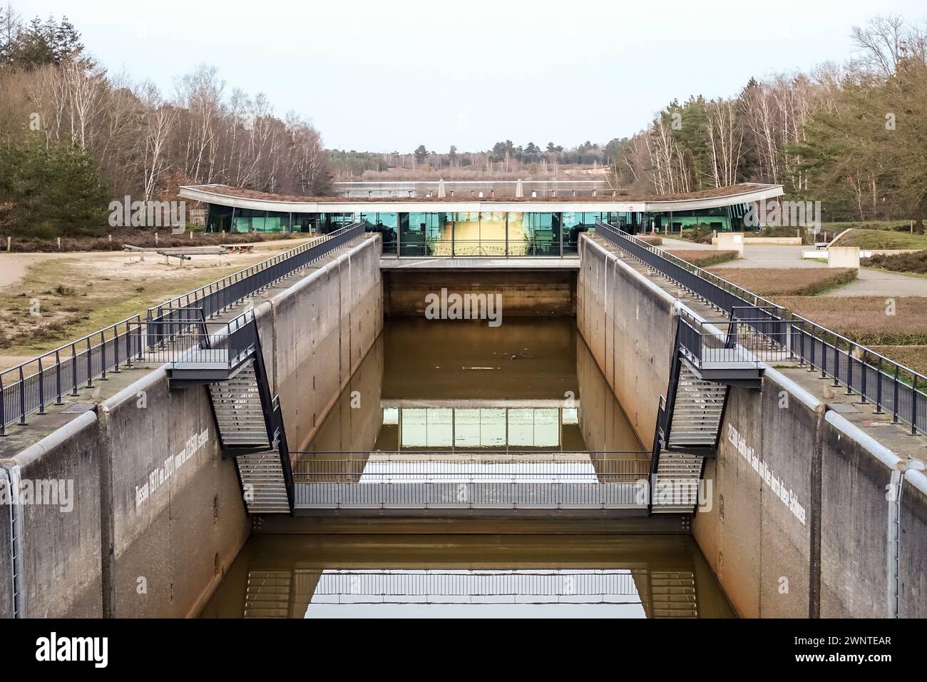 Reindersmeersluis-Struktur am Kanal zwischen Reindersmeer und Maas, mit Wald im Hintergrund an bewölktem Tag Stockfoto