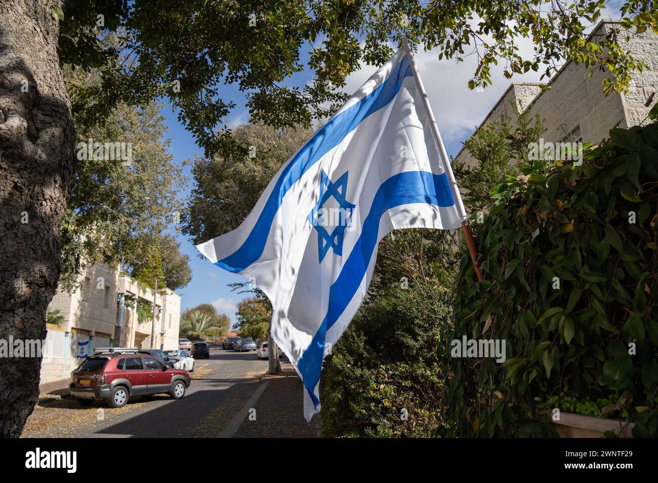 Eine israelische Flagge, die auf einer Straße in Israel gehisst wird, um Einheit und Unterstützung im Kampf gegen den islamischen Terror zu zeigen. Stockfoto