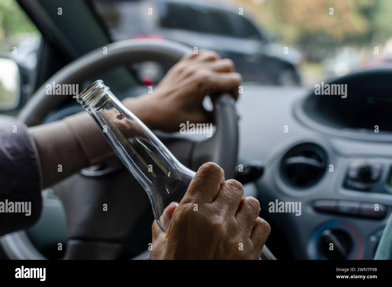 Alkoholkonsum während des Fahrens. Betrunkene Frau, die ein Auto fährt Stockfoto