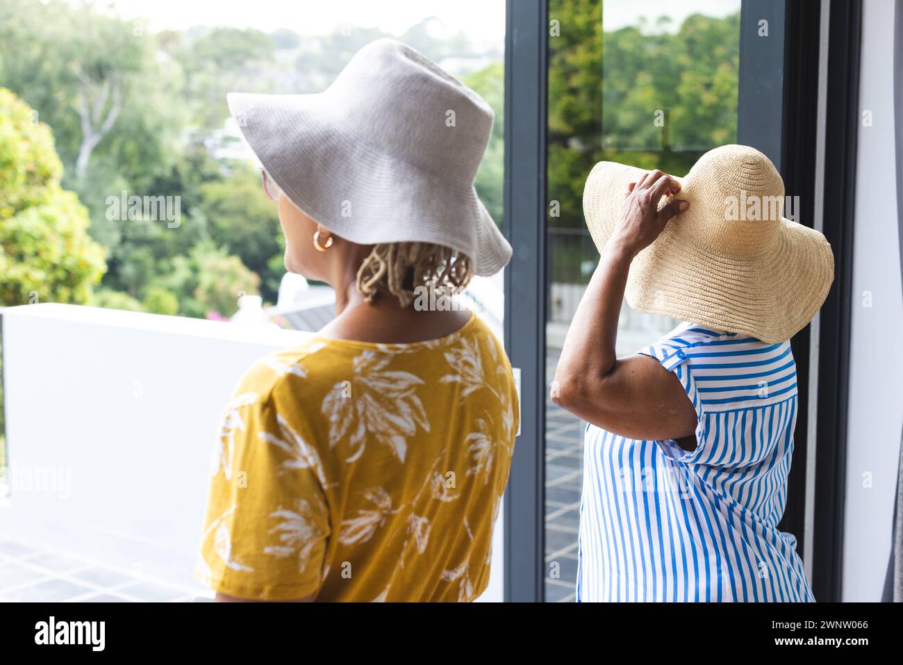 Ältere afroamerikanische Frau und ältere birassische Frau genießen im Urlaub eine Aussicht von einem Balkon Stockfoto