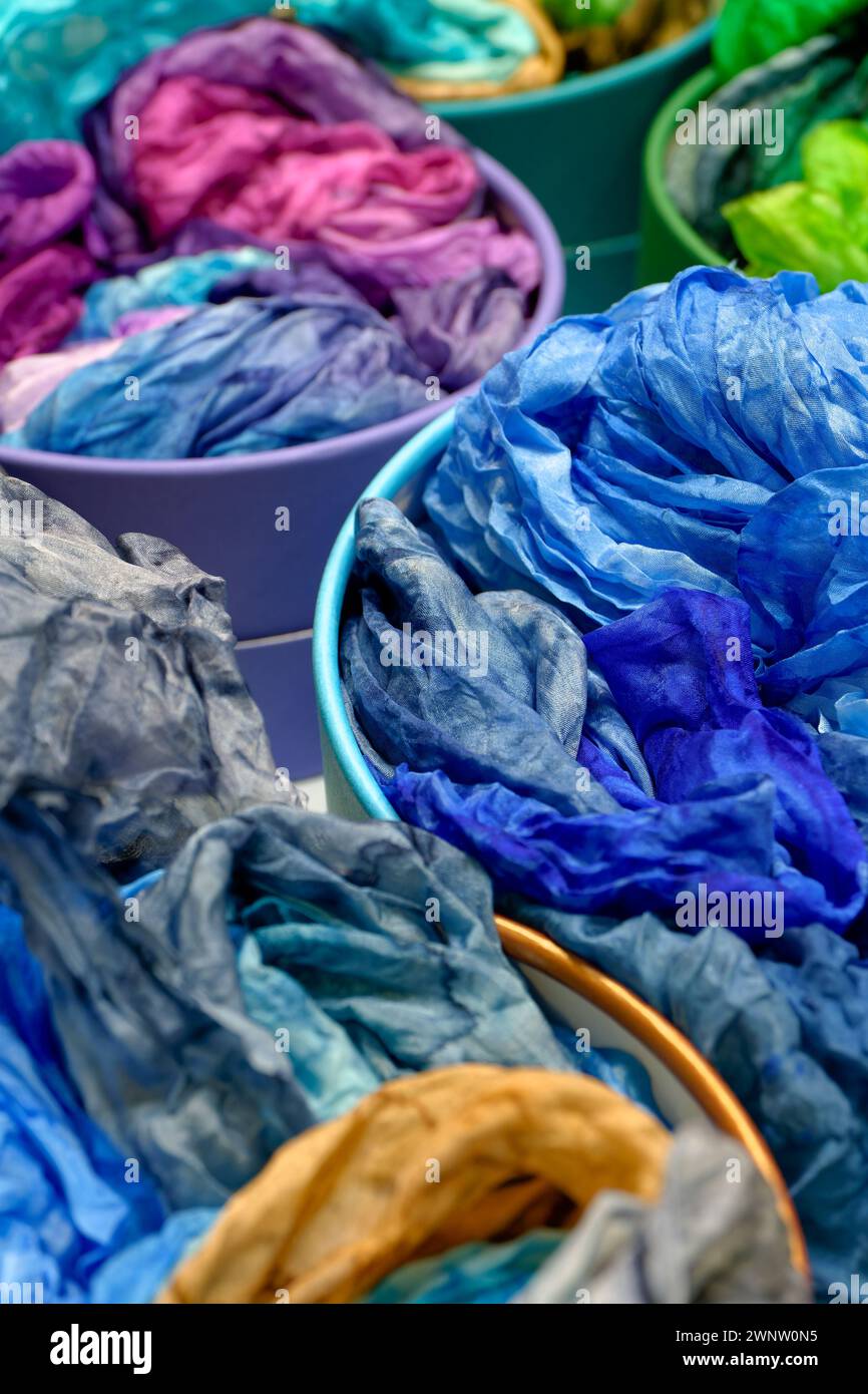 Farbenfrohe traditionelle Seidentücher oder Tücher auf einer Markttheke, abstrakter mehrfarbiger Hintergrund Stockfoto