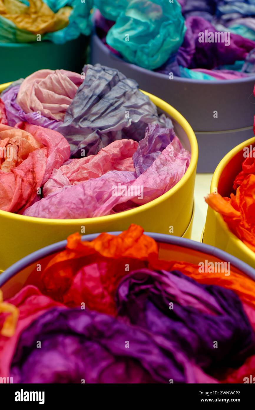 Farbenfrohe traditionelle Seidentücher oder Tücher auf einer Markttheke, abstrakter mehrfarbiger Hintergrund Stockfoto