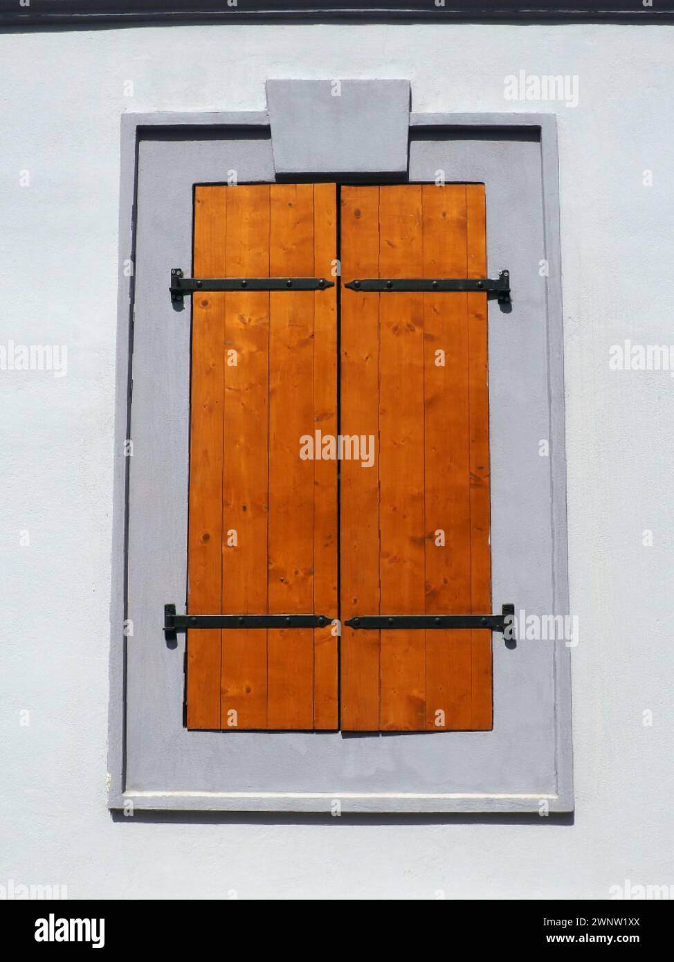 Fenster mit alten Holzläden. Geschweifte Metallspangen. Weiße Wand. Country-STYLE. Petrovaradin, Novi Sad, Serbien. Gebäude im Retro-Stil Stockfoto