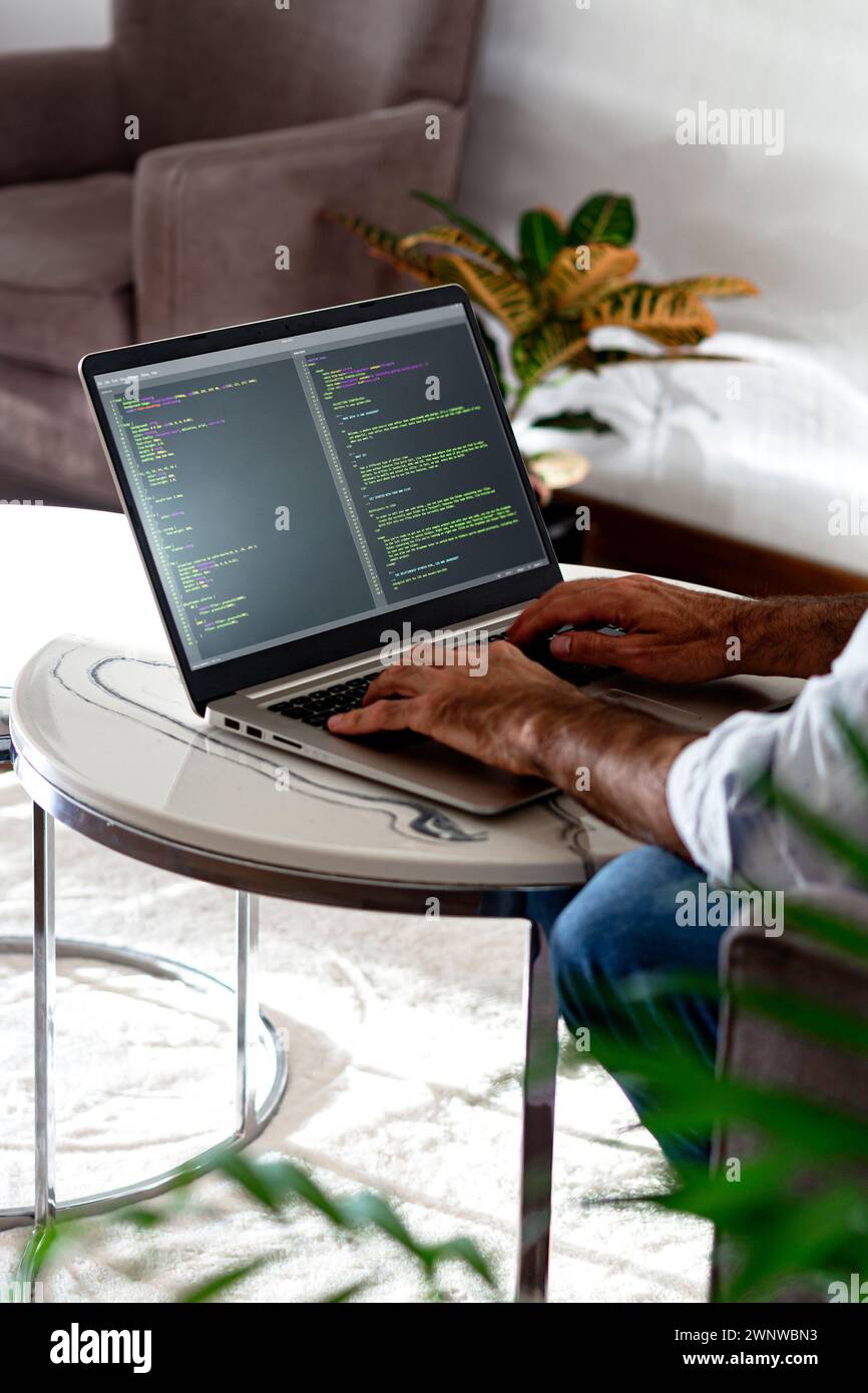 Programmierer, der HTML-javascript-Code in einen Laptop schreibt. Vertikales Format. Stockfoto