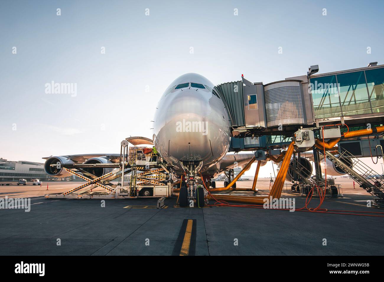 Verladung des Flugzeugs vor dem Abflug. Vorderansicht des Flugzeugs am Flughafen an sonnigem Tag. Stockfoto