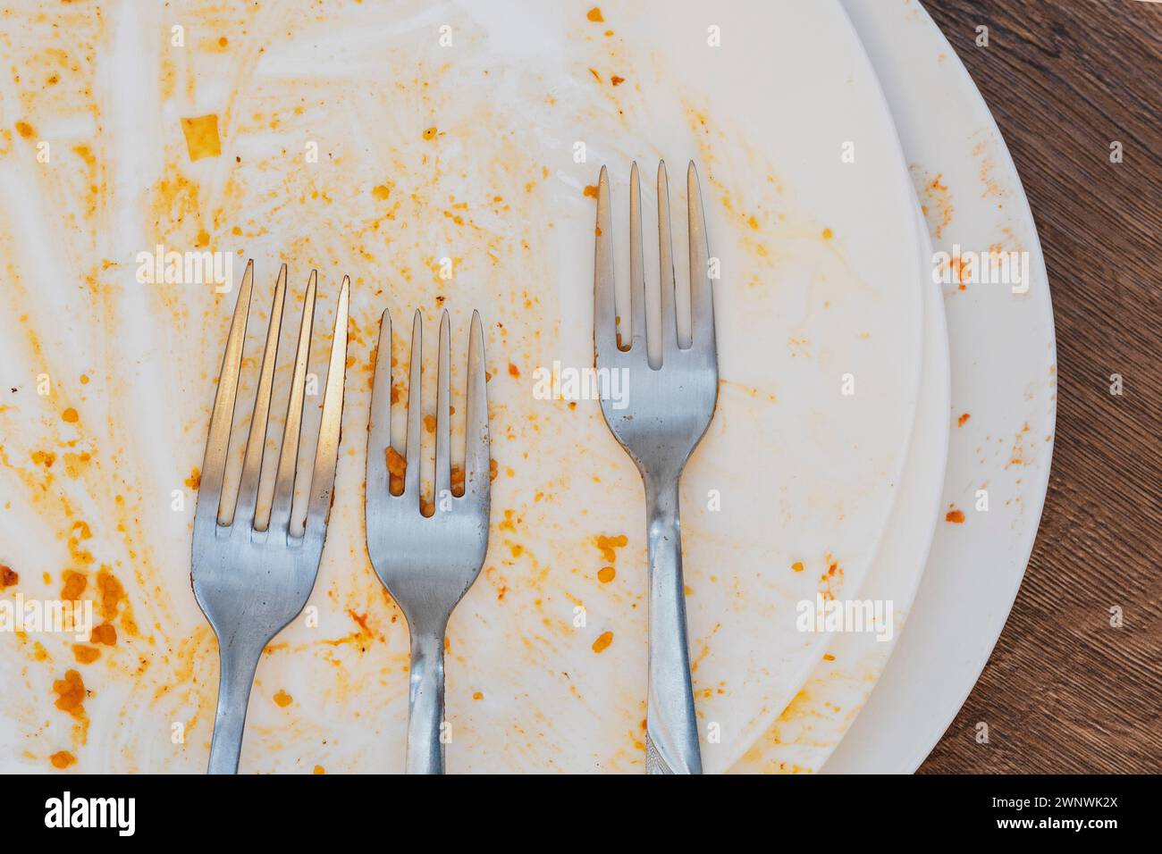 Schmutzige Teller nach dem Essen. Besteck. Gabeln auf einer Platte. Schmutziges Geschirr nach dem Essen. Ende der Mahlzeit. Guter Appetit, leckeres Essen und ein gutes Konzept Stockfoto