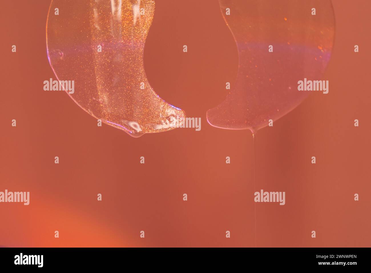 Transparente Augenflecken hängen vor rotem Hintergrund Stockfoto