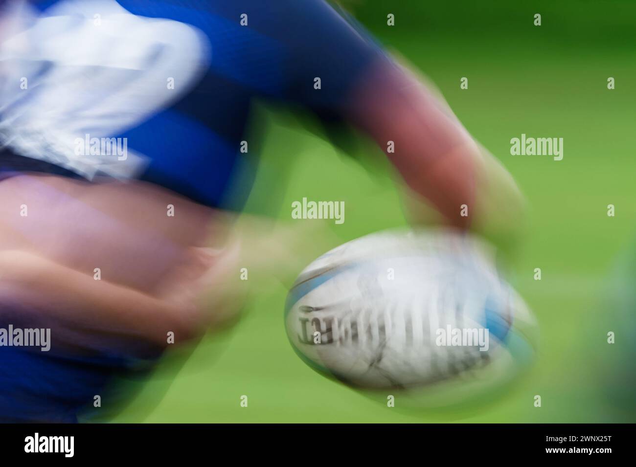 Motion Blur zeigt Bewegung als Rugbyspieler, während er Einen Rugbyball in einer Hand hält, Christchurch, großbritannien Stockfoto