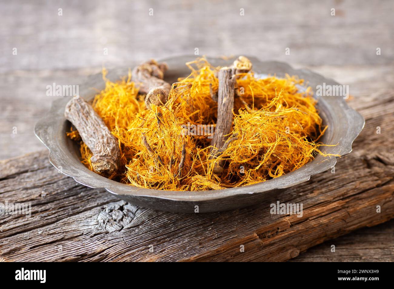Süßholzwurzel, Süßholzfaser in Schüssel auf rustikalem Hintergrund ( glycyrrhiza glabra ) Stockfoto