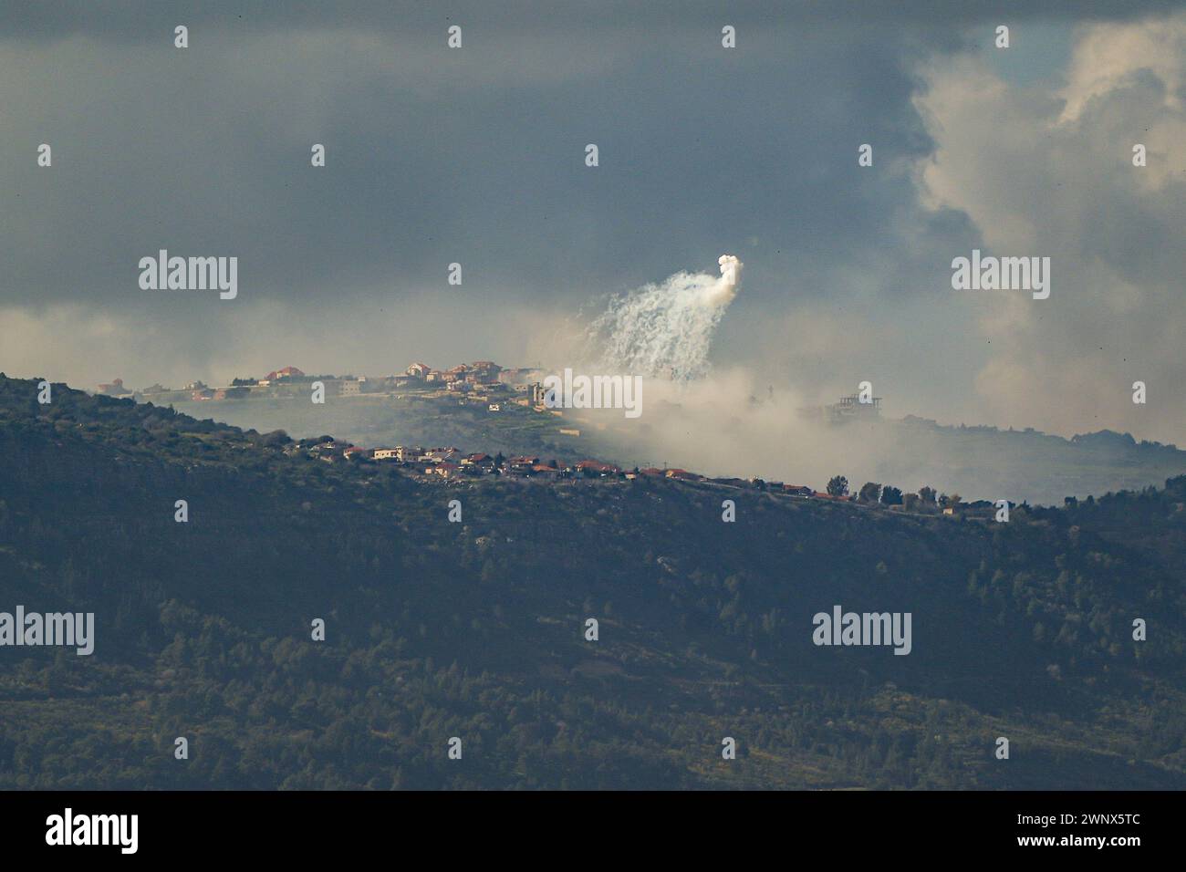 (240304) -- GRENZE ZWISCHEN ISRAEL und LIBANON, 4. März 2024 (Xinhua) -- Rauch steigt aus dem libanesischen Dorf Markaba als Folge der israelischen Bombardierung am 4. März 2024 im Südlibanon neben der Grenze zu Israel auf. Ein indischer Staatsangehöriger wurde am Montag im Norden Israels durch einen Raketenabwehrangriff der Hisbollah im Libanon getötet und sieben weitere verletzt, sagten israelische Quellen. Die israelische Armee reagierte, indem sie Panzer- und Artilleriefeuer auf die Quelle des Raketenangriffs feuerte, so ein israelischer Militärsprecher. (Ayal Margolin/JINI über Xinhua) Stockfoto