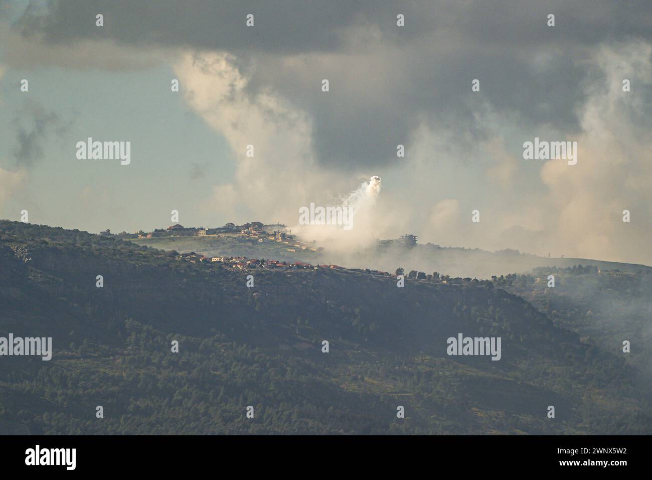 (240304) -- GRENZE ZWISCHEN ISRAEL und LIBANON, 4. März 2024 (Xinhua) -- Rauch steigt aus dem libanesischen Dorf Markaba als Folge der israelischen Bombardierung am 4. März 2024 im Südlibanon neben der Grenze zu Israel auf. Ein indischer Staatsangehöriger wurde am Montag im Norden Israels durch einen Raketenabwehrangriff der Hisbollah im Libanon getötet und sieben weitere verletzt, sagten israelische Quellen. Die israelische Armee reagierte, indem sie Panzer- und Artilleriefeuer auf die Quelle des Raketenangriffs feuerte, so ein israelischer Militärsprecher. (Ayal Margolin/JINI über Xinhua) Stockfoto