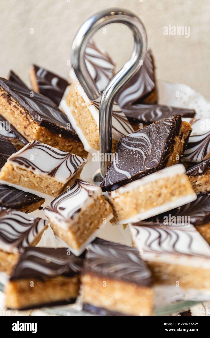 Vertikale Fotos kunstvoll marmorierte Schokolade schmückt diese verführerischen arabischen Leckereien. Jedes Stück ist eine perfekte Mischung aus Tradition und Gourmet, die auf einem Elg präsentiert wird Stockfoto